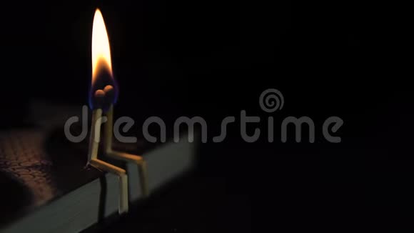 黑暗中一本书上两根燃烧的火柴爱的概念视频的预览图