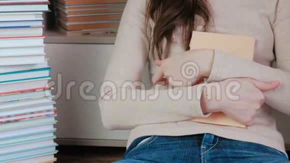 女人的手紧紧地抱着本书视频的预览图