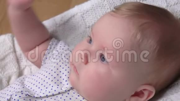 蓝眼睛的婴儿躺在毯子上环顾四周视频的预览图