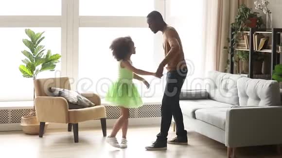 快乐的非洲爸爸和小女儿在客厅跳舞视频的预览图