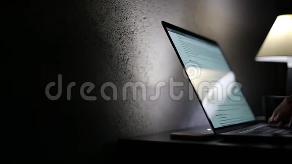 在黑暗的房间里在笔记本电脑键盘上输入女性手的特写视频的预览图