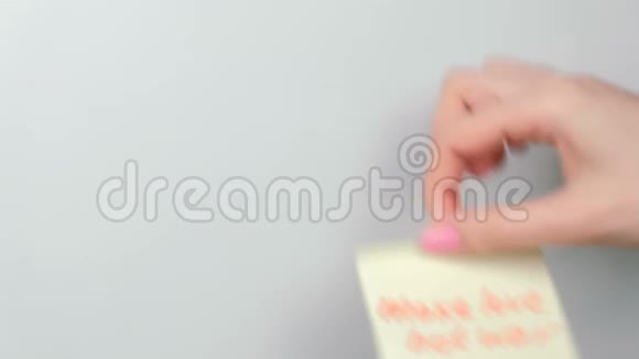 特写女人手贴黄色贴纸纸用文字使爱情不战视频的预览图