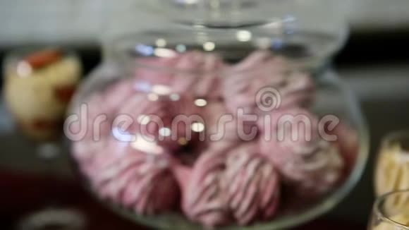 把注意力集中在带有粉红色棉花糖的大玻璃容器上视频的预览图