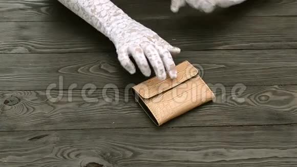 女人手戴着白色花边手套数着棕色皮包里的美元钞票视频的预览图