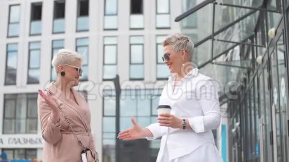 两个女商人站在外面喝咖啡背景是建筑物视频的预览图