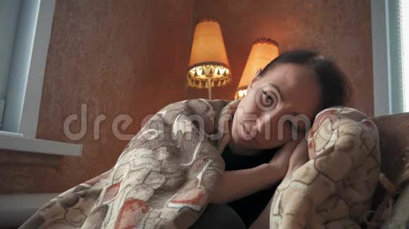 沮丧悲伤的女人双手抱着头坐在家里的扶手椅上充满魅力和悲伤的生活方式戏剧性的肖像视频的预览图