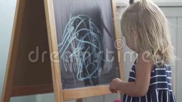 小女孩在黑板上画蓝色粉笔视频的预览图
