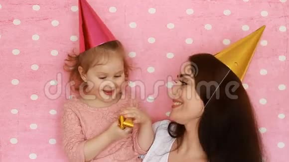 家庭幸福母女俩吹喇叭微笑拥抱笑和庆祝生日一个女人和她视频的预览图