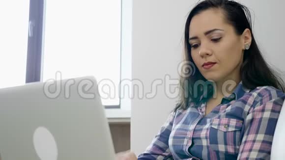 打哈欠的女人在电脑上工作视频的预览图