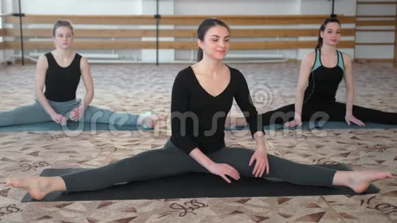 在健身班做瑜伽伸展运动的年轻女性视频的预览图