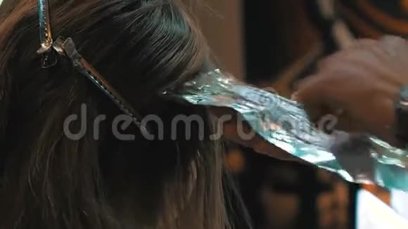 头发着色施染色剂年轻女子在理发店里染发视频的预览图