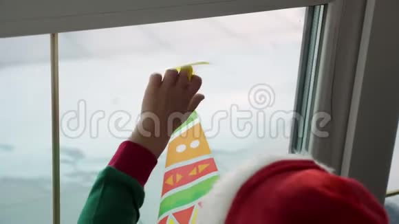 特写人们用圣诞装饰品贴纸装饰房子里的窗户视频的预览图