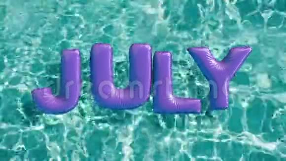 单词七月形状的充气游泳圈漂浮在清爽的蓝色游泳池里视频的预览图