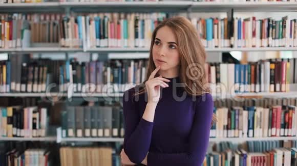 体贴的年轻女子站在图书馆的书架前视频的预览图