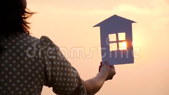 太阳落山时手里拿着纸房子的剪影视频的预览图