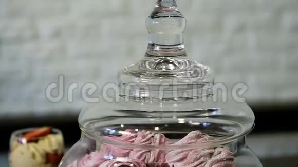 带粉红色棉花糖的大玻璃容器上的全景视频的预览图