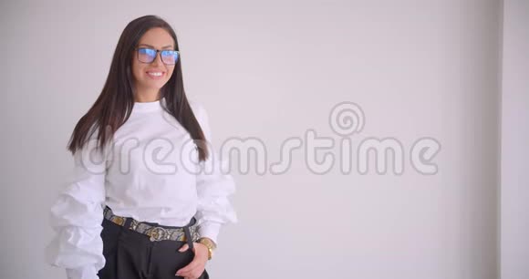 年轻漂亮的白种人女商人戴着眼镜看着镜头高兴地笑着的特写照片视频的预览图