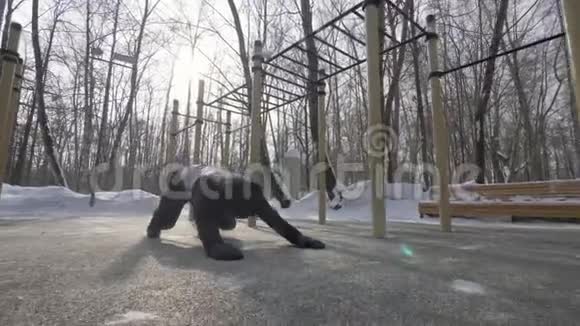 在冬季运动训练中做俯卧撑和伸展运动的健身男子视频的预览图
