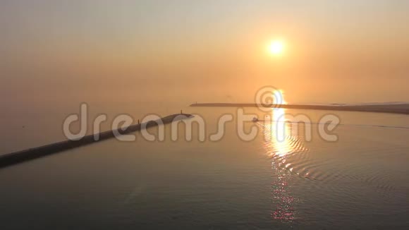 孤舟缓缓离开港湾在宁静的海洋中驶入夕阳视频的预览图