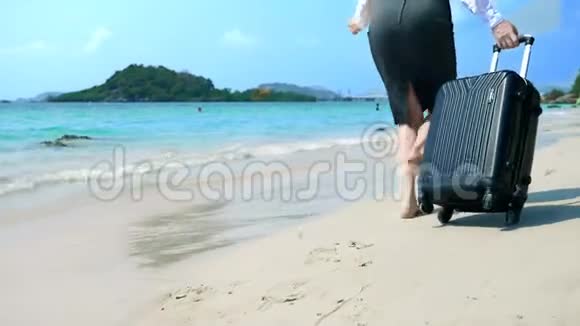 穿着办公室服装的女商人光着脚沿着一片白色的沙滩奔向大海自由职业者期待已久的假期视频的预览图