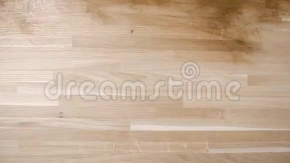 从建筑工人的上方射出用布小心地在光滑的木头上涂上油视频的预览图