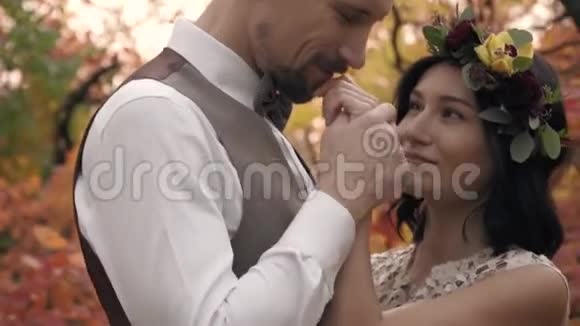 高贵的男人吻他情人的手然后吻她的额头在秋天的公园里射击视频的预览图