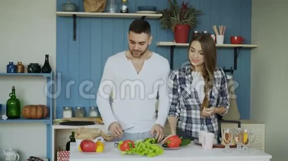快乐的年轻夫妇在厨房有魅力的舞蹈男在早上帮女朋友做饭视频的预览图