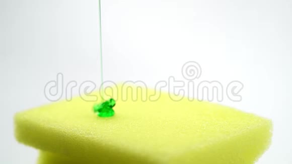 超级宏观关闭黄色海绵的镜头为盘子和倒入洗涤剂的形式绿色凝胶视频的预览图