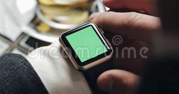 关闭商务人员手与智能手表绿色屏幕色度键开启敲击和滚动运动舒适视频的预览图
