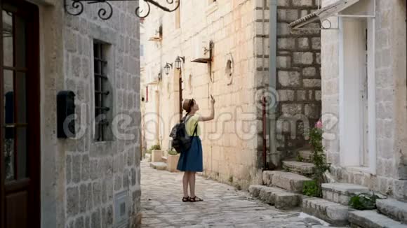 年轻开朗的旅行女孩在欧洲城市散步在黑山旅行观看Perast地标漂亮的女人视频的预览图
