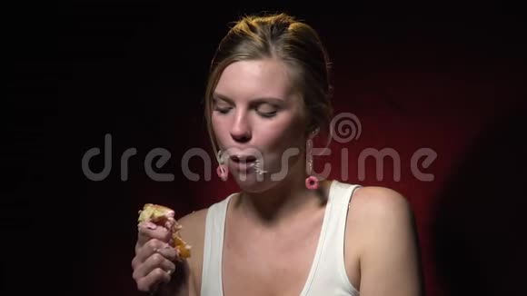 金发女郎穿着白色T恤享受带奶油的甜甜圈动作缓慢视频的预览图