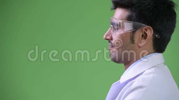 年轻英俊的波斯男子医生戴着防护眼镜的侧写视图视频的预览图
