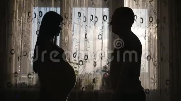 女人在等孩子一男一女靠窗的剪影视频的预览图