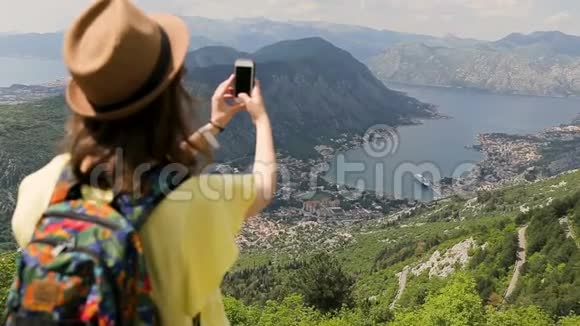 年轻的女游客带着帽子和黄色衬衫在手机上拍照旅行者在科托湾拍照视频的预览图