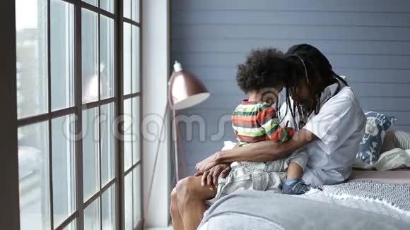英俊的非洲男人在卧室里和儿子说话视频的预览图