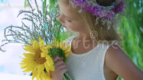 戴着花冠的小金发手捧着花对着镜头微笑视频的预览图