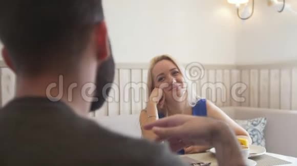 快乐的年轻夫妇在咖啡厅边吃甜点边聊天视频的预览图