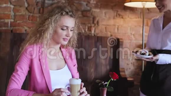 咖啡馆里的女人喝着巧克力糖果的咖啡视频的预览图