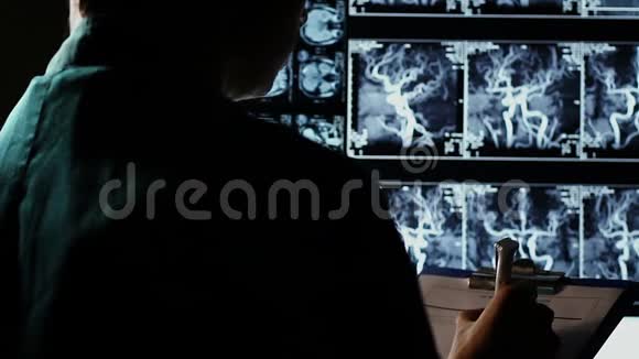 医生研究人体X线图像写下诊断视频的预览图