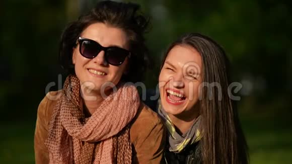 两个快乐的女孩在公园里一起看镜头和微笑有吸引力的布鲁姆视频的预览图
