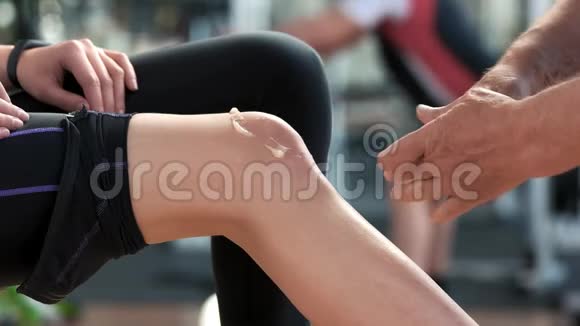 治疗师在女性膝盖上涂抹药膏霜视频的预览图