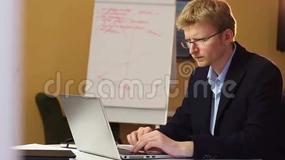 戴着笔记本电脑打印电子邮件眼镜的金发商人视频的预览图