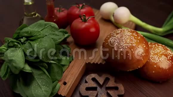 视频展示制作美味汉堡新鲜蔬菜和烹饪用蔬菜芝麻面包的配料视频的预览图