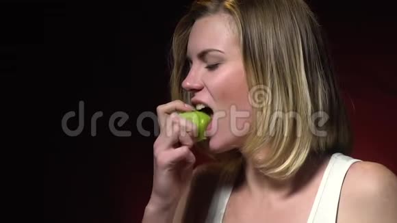 一个穿着白色T恤的女孩正在吃奇异果慢动作视频的预览图