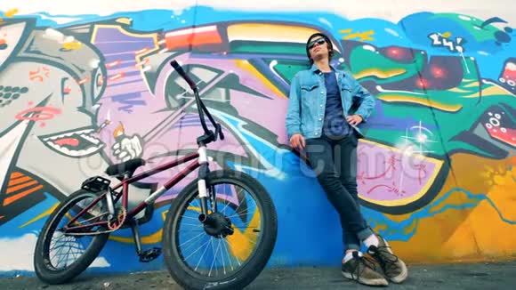 街头涂鸦墙上站着一个年轻人视频的预览图