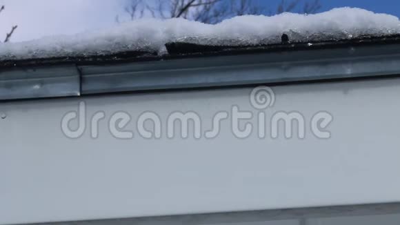 春天的概念水滴从白雪覆盖的木屋的屋顶上掉下来视频的预览图