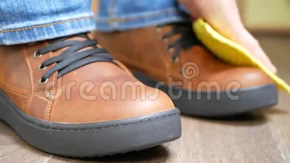 用黄色抹布手工抹棕色皮鞋视频的预览图
