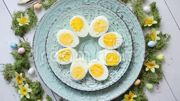 复活节摆满鲜花和鸡蛋带有煮鸡蛋的装饰盘视频的预览图