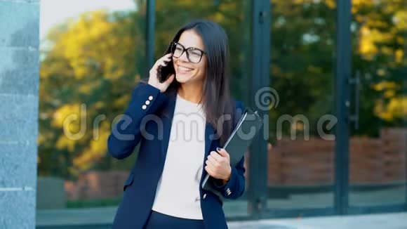 女商人用手机交谈戴着眼镜穿着正式西装的女商人与视频的预览图