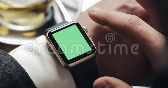 关闭商务人员手与智能手表绿色屏幕色度键开启敲击和滚动运动舒适视频的预览图